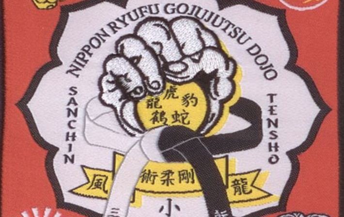 Nippon Ryufu Gojujutsu Dojo martial arts patch featuring a fist emblem, black and white belts, and Japanese kanji, symbolizing strength and discipline in traditional martial arts.